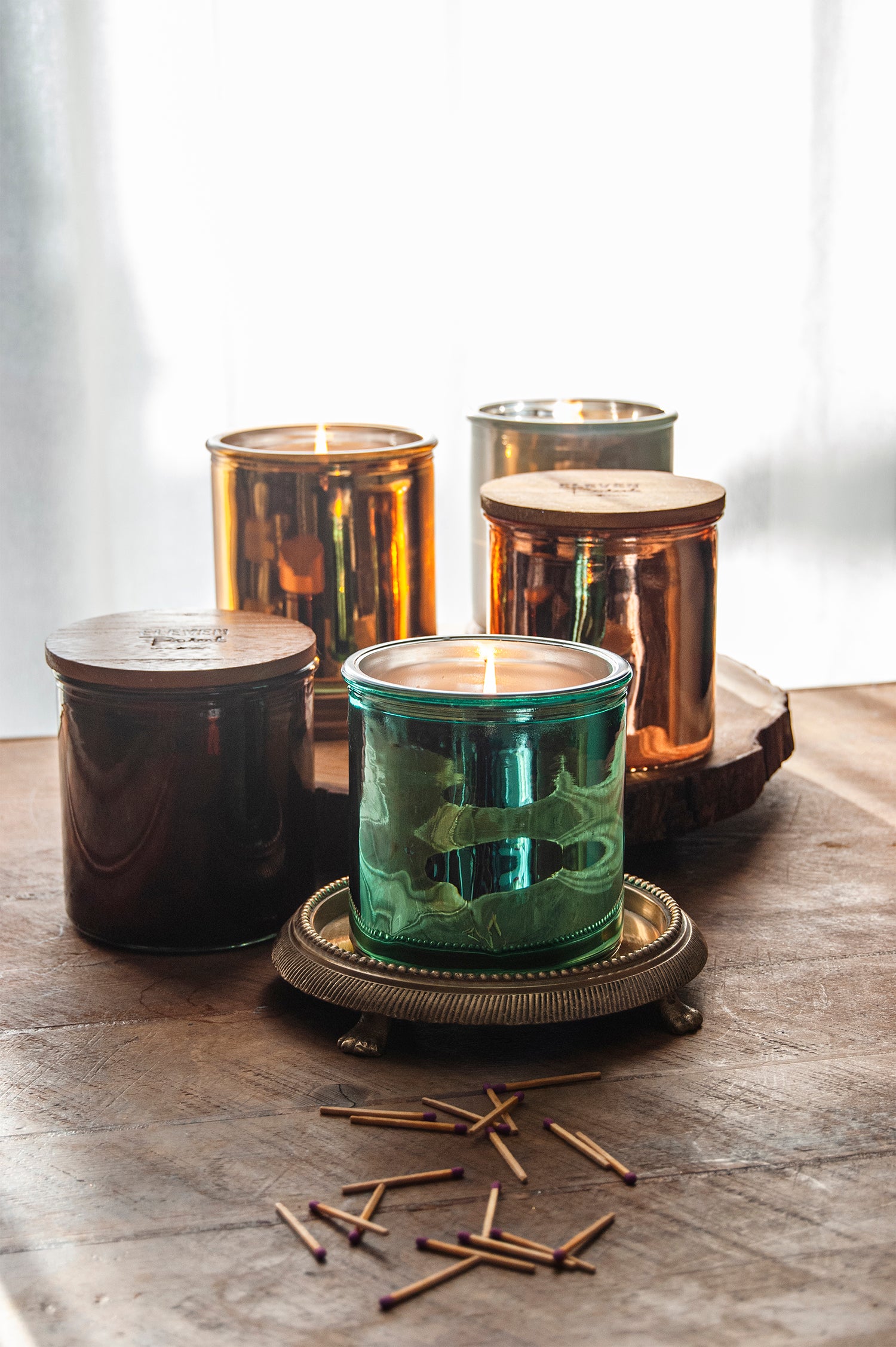 Rock Star Candle Collection on weathered wooden table with matches strewn on the table